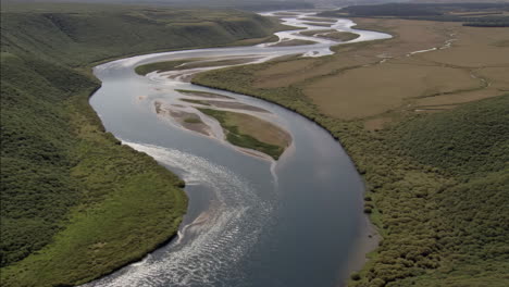 aerial view of a winding river through a green valley