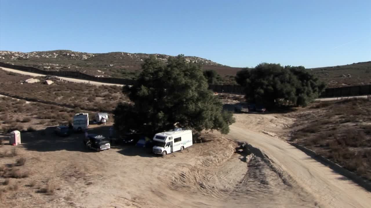 캠핑카는 외딴 지역의 나무 아래에 주차되어 있습니다.