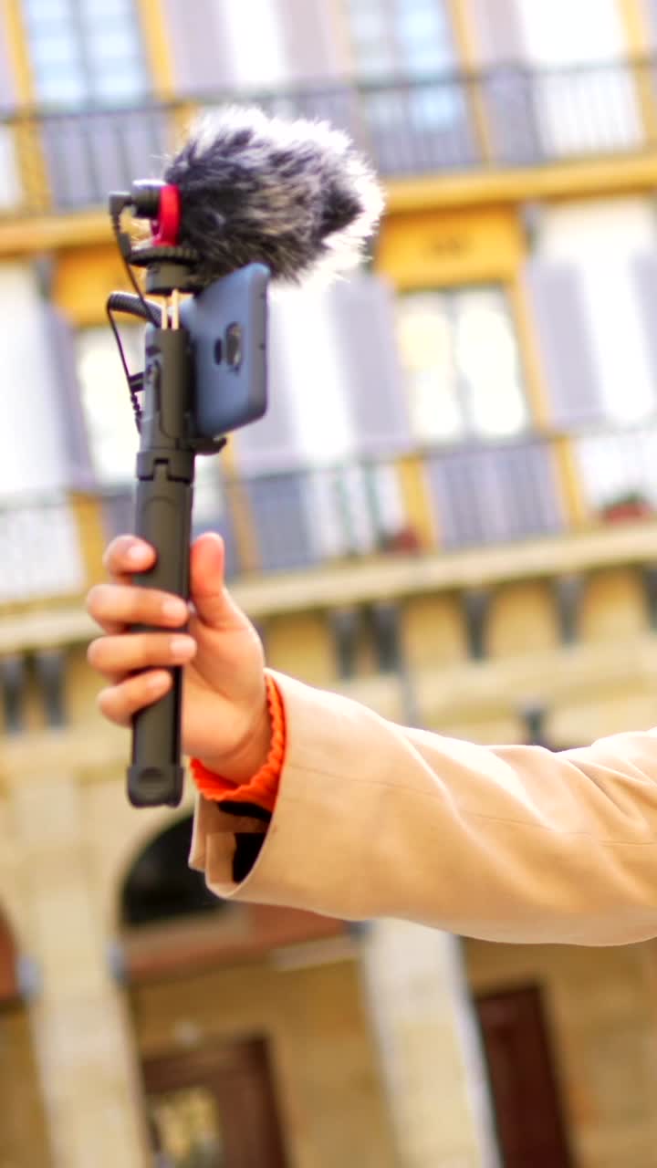 Person vlogging with smartphone and microphone