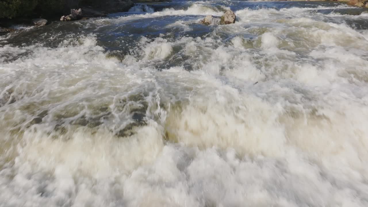 Rushing waterfall in Owen Sound, Canada during daylight with powerful water flow and splashing