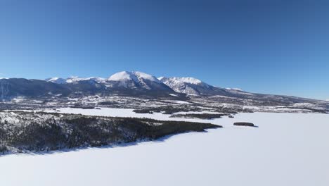 frozen dillon reservoir and snow capped mountain range in colorado