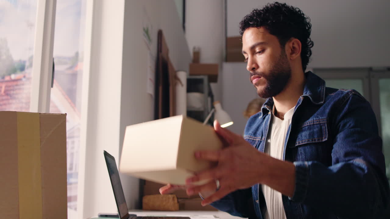 Young Man Preparing Package for Shipping in Home Office