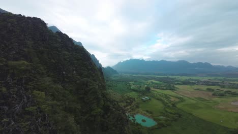scenic aerial view over the blue lagoon in laos, with green forests, river bends, and rugged cliffs surrounding the water