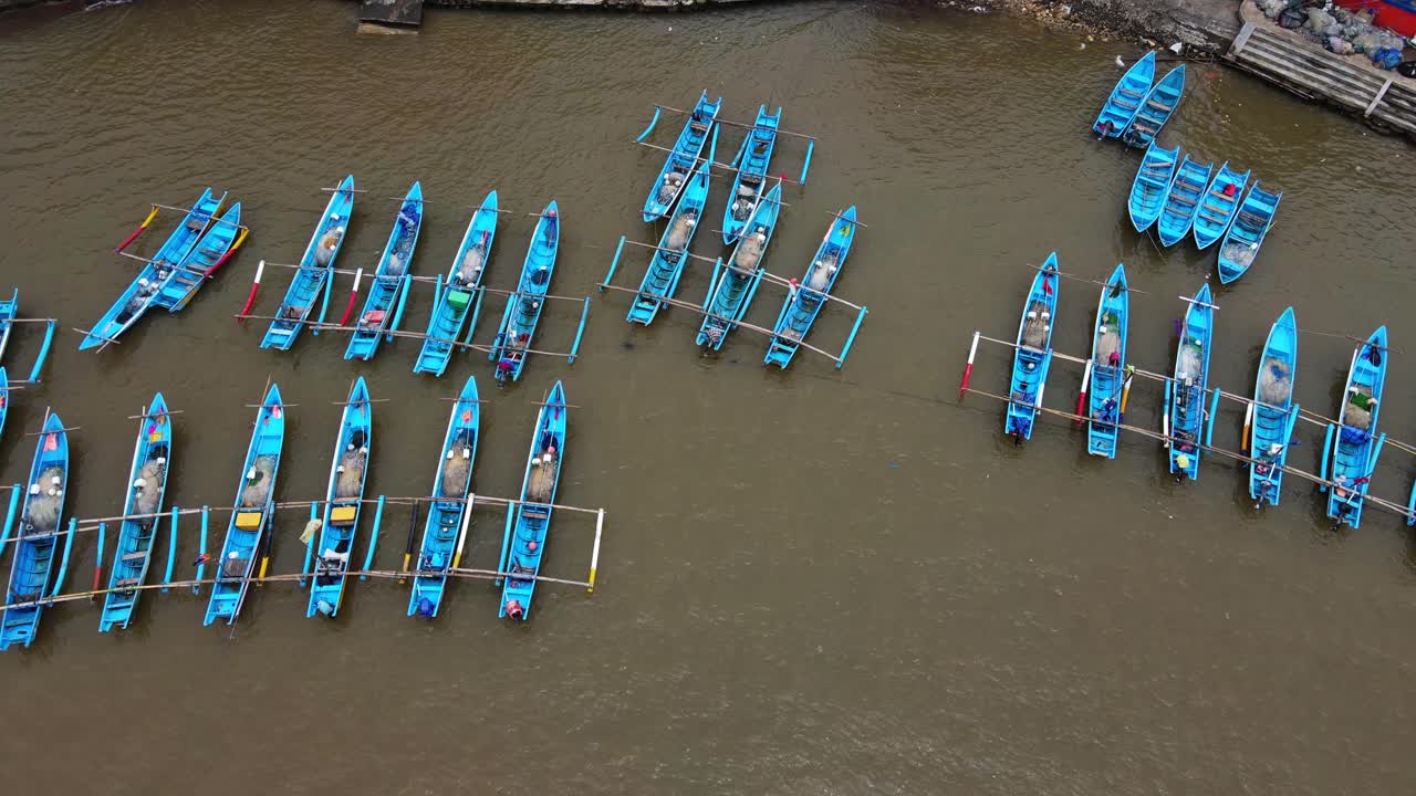 toma aérea de arriba hacia abajo estacionamiento tradicional de pescadores de color azul en el puerto de baron beach, yogyakarta, indonesia