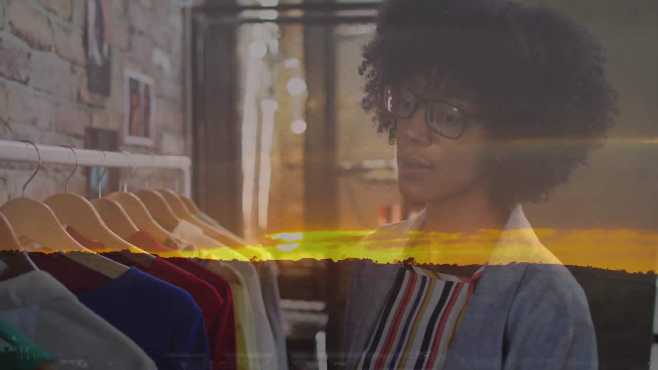 Animation of landscape over african american female designer