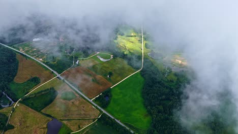 top drone shot of partial view of agriculture fields by clouds in a countryside