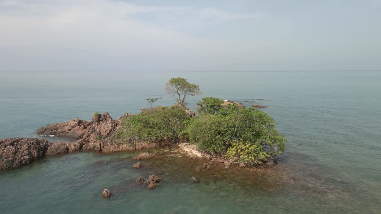 Aerial drone orbit shot of a small deserted rocky tropical island