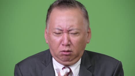 mature japanese businessman feeling sick