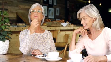 Senior-women-talking-to-each-other-in-cafe-4k