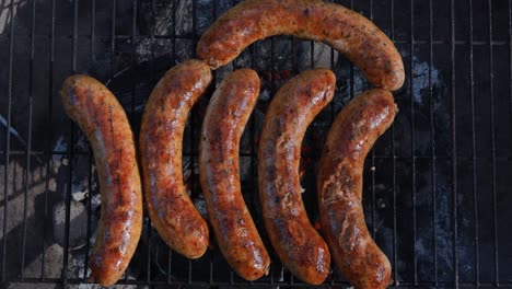 Delicious-juicy-sausages,-cooked-on-the-grill-with-a-fire.