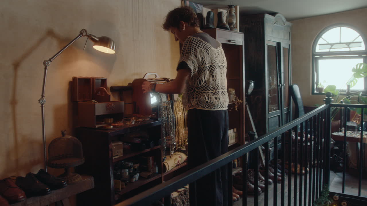 Woman Walking Upstairs in Vintage Store and Taking Items for Sale