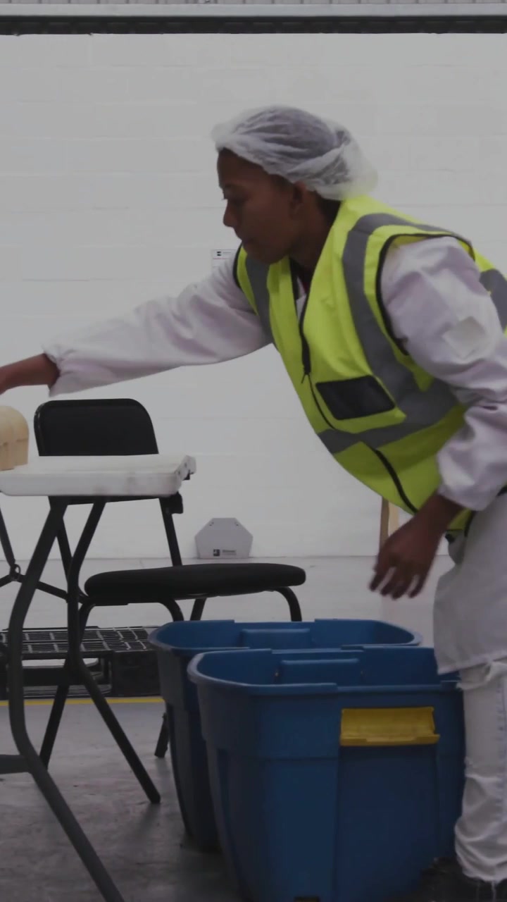 Food packer approaching bin and placing wrapped items for packing while eco icons popping nearby