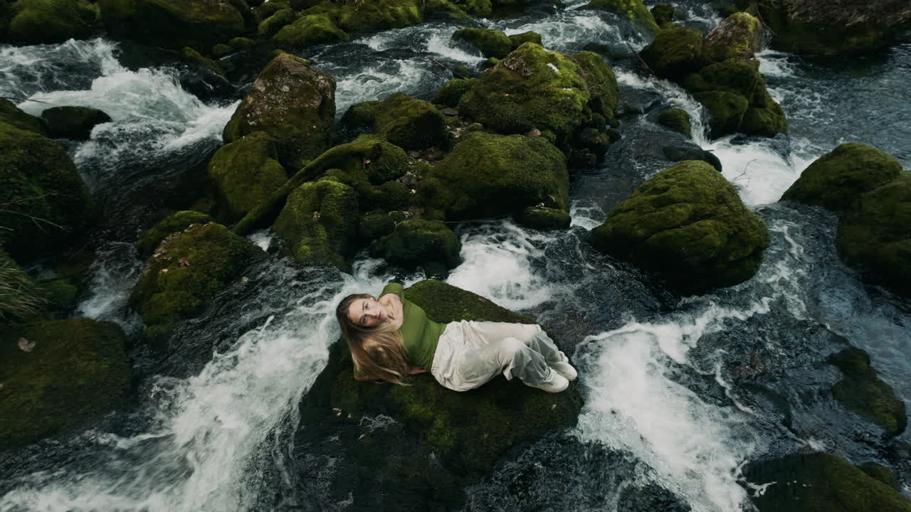 Woman Relaxing by a Mossy River