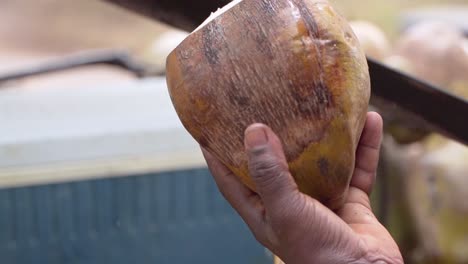 el hombre prepara agua de coco con un cuchillo grande, es una bebida exquisita y saludable, toma de primer plano en cámara lenta