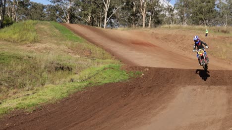 dirt bike riders compete on a rural track