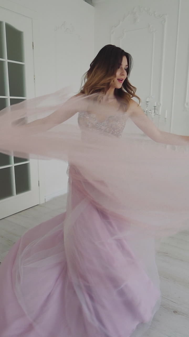 Classical young gourgeous bride. View of young smiling bride dancing in studio room Vertical video