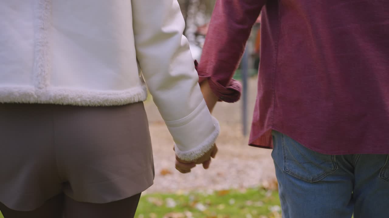 a couple holding hands while exploring a park in port coquitlam.