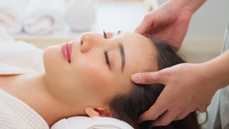 una mujer recibiendo un masaje de cabeza en un spa.