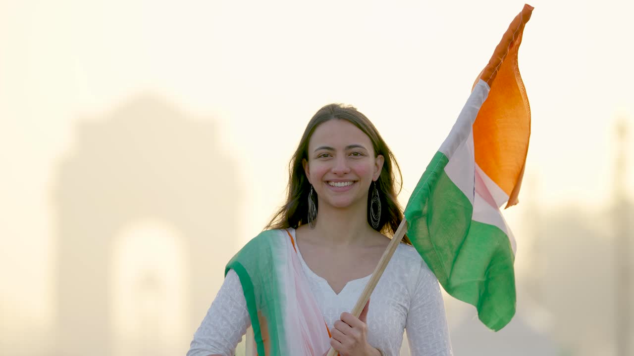индийская девушка поднимает индийский флаг с гордостью в индийской традиционной одежде на воротах индии в дели
