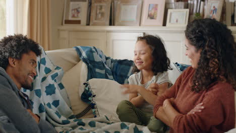 adorable little girl playing game with mother and father at home having fun relaxing on sofa with child enjoying weekend together 4k