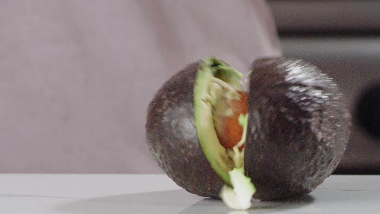 Avocado being dropped and splitting in half