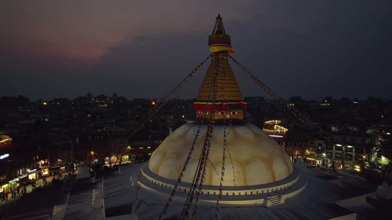 Una serena ripresa aerea notturna dello stupa di Boudhanath, patrimonio mondiale dell'UNESCO. Il sacro punto di riferimento buddista risplende meravigliosamente sopra il pacifico skyline serale di Kathmandu