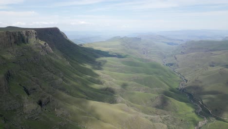 colinas verdes y ondulantes se erosionan debajo de acantilados altos y escarpados de la meseta montañosa