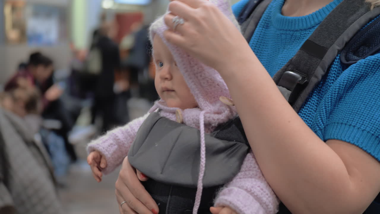 Mum with baby daughter in kangaroo carrier at the airport