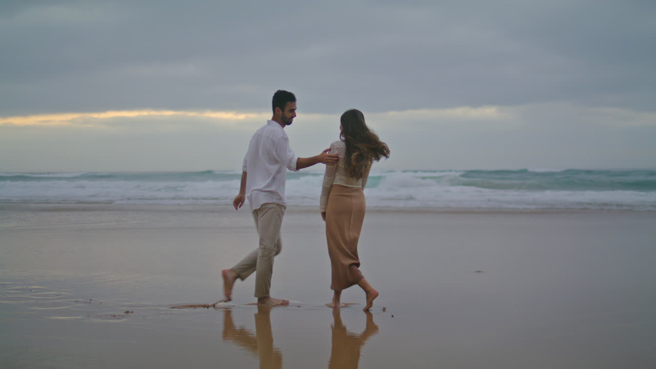 Happy sweethearts walking evening beach outdoors. Hispanic couple running nature