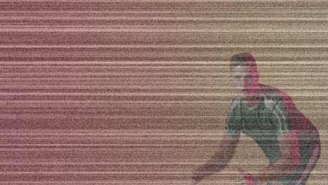 man crouching on studio floor, with glitch noise lines highlighting technology concept