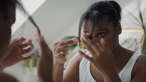 Mujer-Afroamericana-Comprobando-El-Estado-Del-Cabello-En-El-Baño.