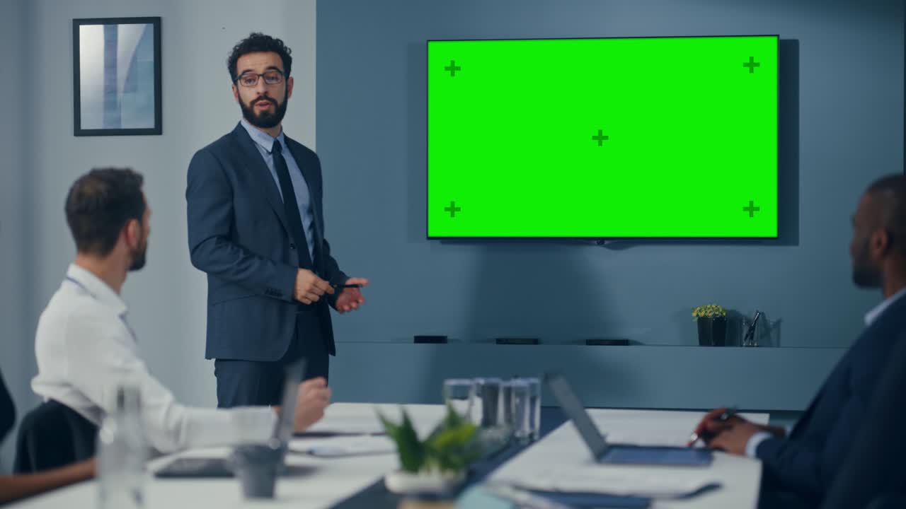 presentación de la reunión en la sala de conferencias de la oficina: el hombre de negocios guapo habla, usa pantalla verde chroma key wall tv. presentación exitosa del producto de comercio electrónico a un grupo de inversores multiétnicos