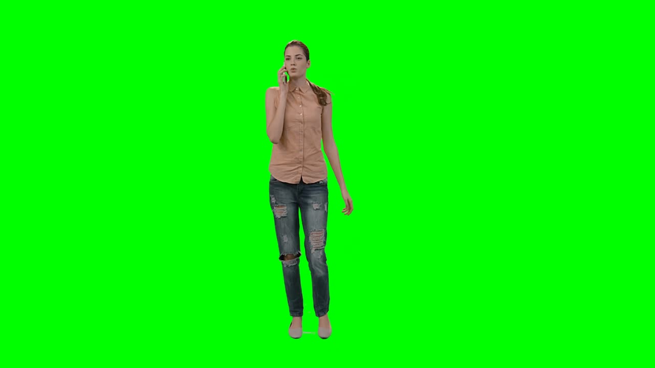 Woman talking on mobile phone against green screen