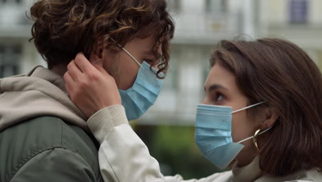 Amor-Pareja-Abrazándose-En-La-Calle-Urbana.-Mujer-Con-Mascarilla-Médica-Tocando-El-Pelo-Del-Hombre.