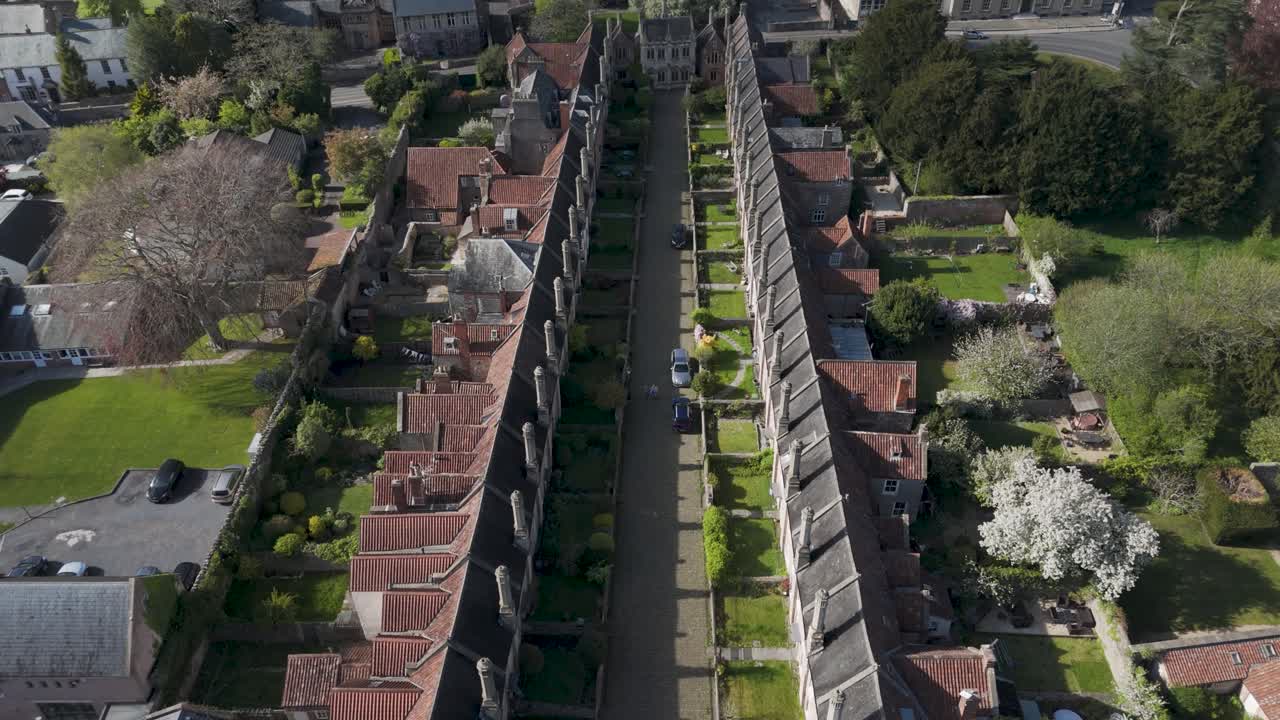 Straight-down aerial of Vicars’ Close displaying parallel medieval terraces, stone chimneys and green verge exemplifying Europe’s oldest intact residential street