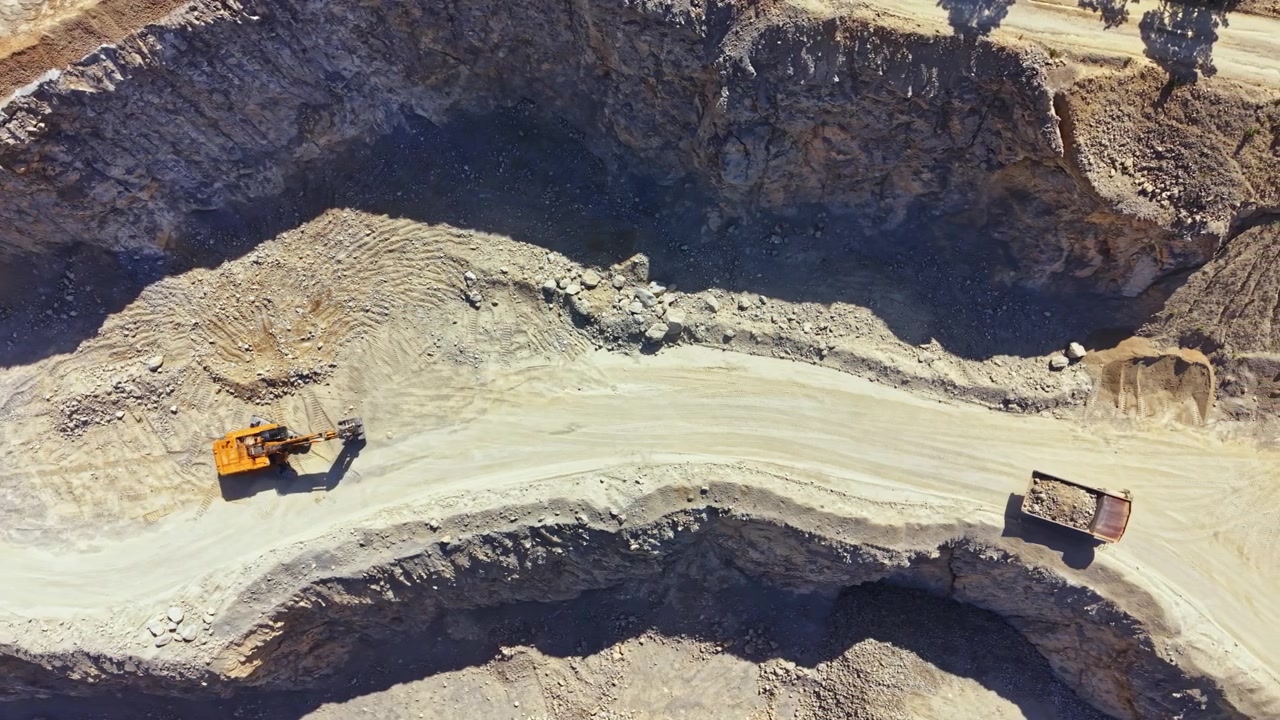 Excavator working on a road in a quarry during the daytime