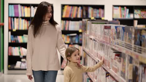 Mother-and-daughter-are-choosing-toys-on-the-shelf-in-the-mall