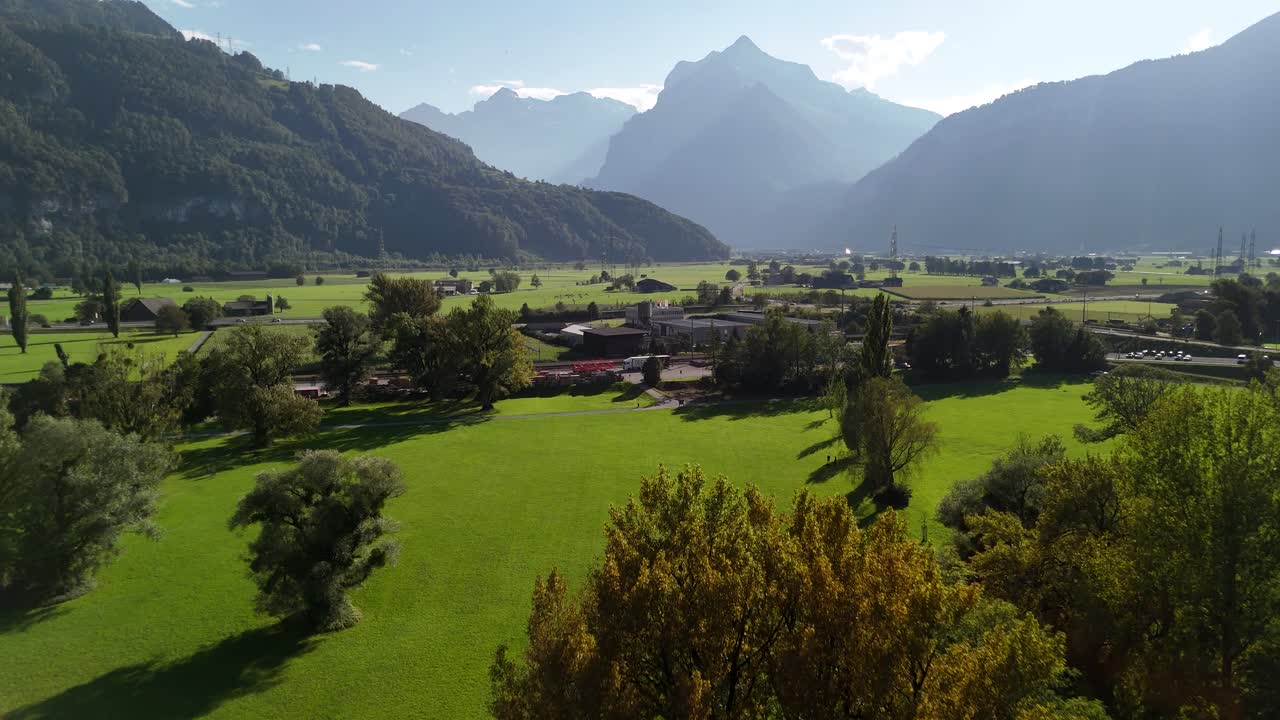 Mountains skyline Switzerland nature aerial drone above forest, isolated village