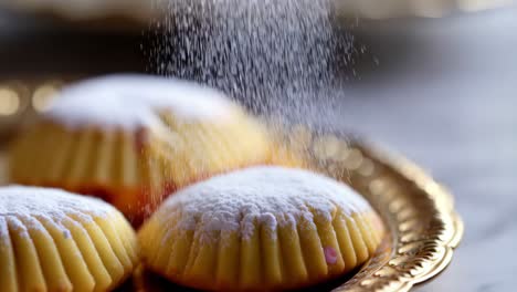 sprinkling powdered sugar on delicious ma'amoul cookies