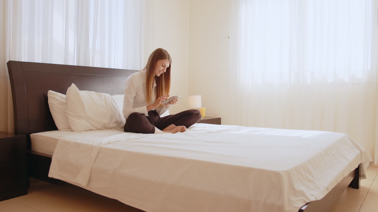 mujer usando teléfono inteligente en la cama