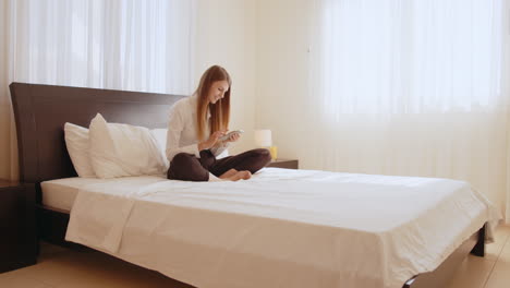 mujer usando teléfono inteligente en la cama