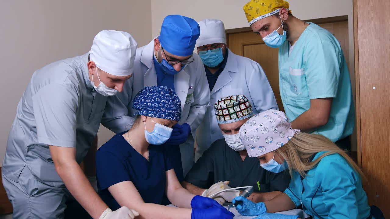 Female student practicing usage of drill machine. Colleagues and teachers are standing and watching around.