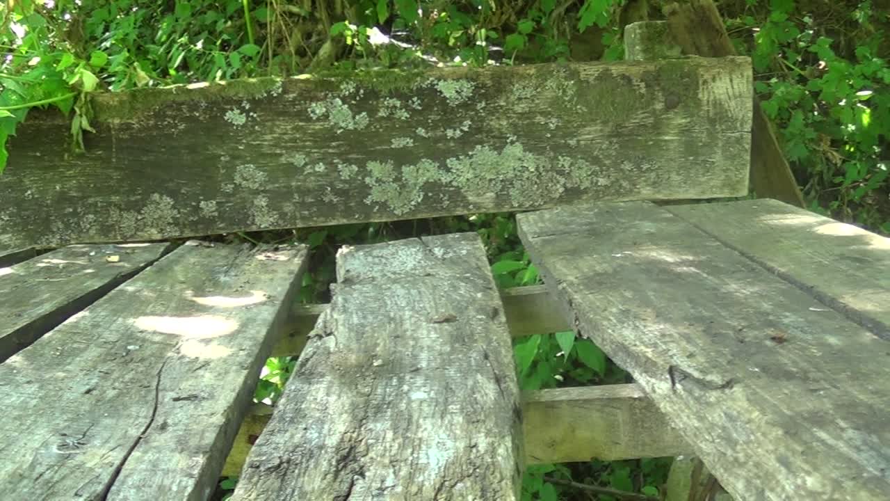 mesa de madera abandonada con banco en la montaña