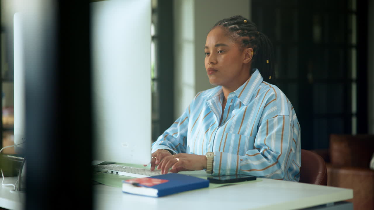 Young Black Woman Typing on Computer Keyboard in Office