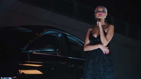 elegant woman by a luxury car at night