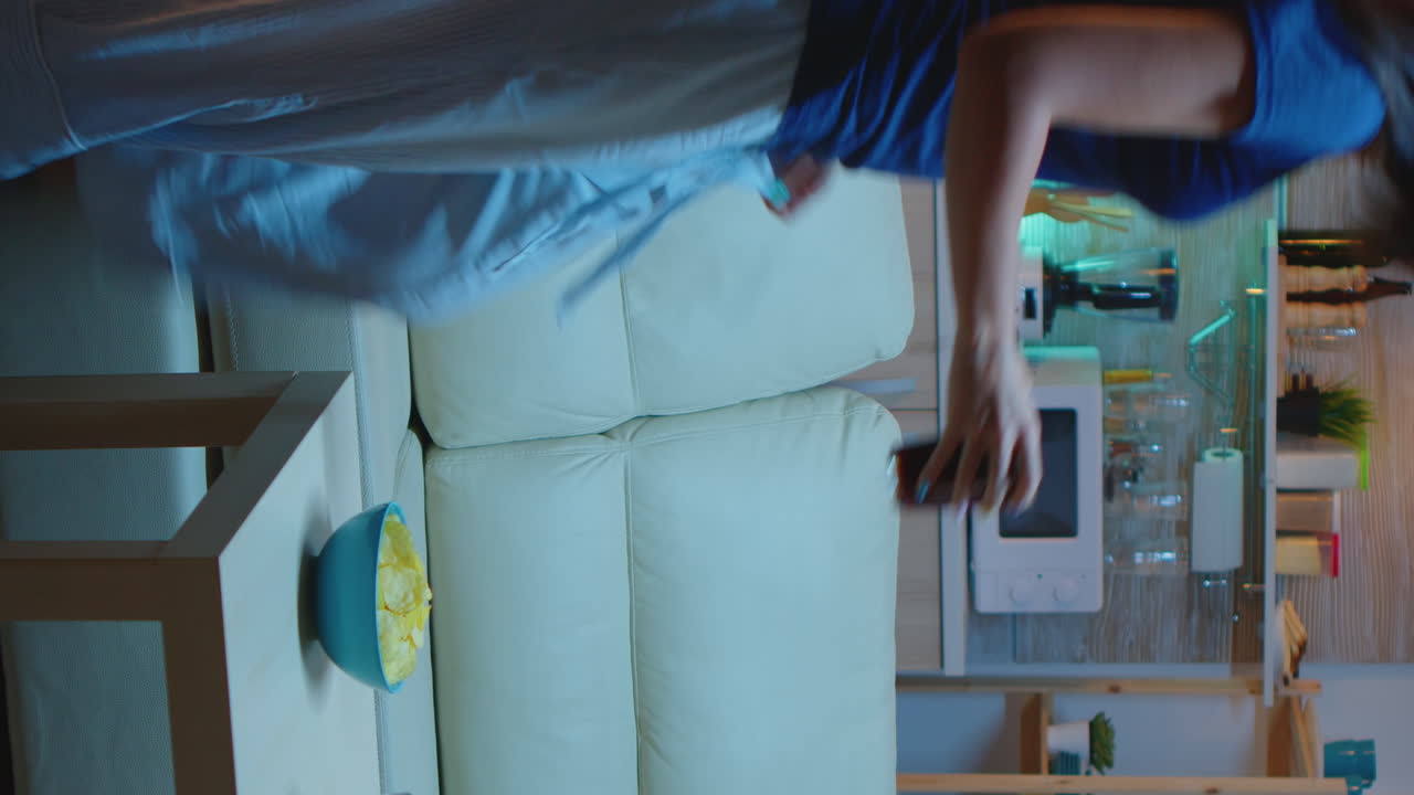 Vertical Video: Lady Resting With Snaks Watching A Movie