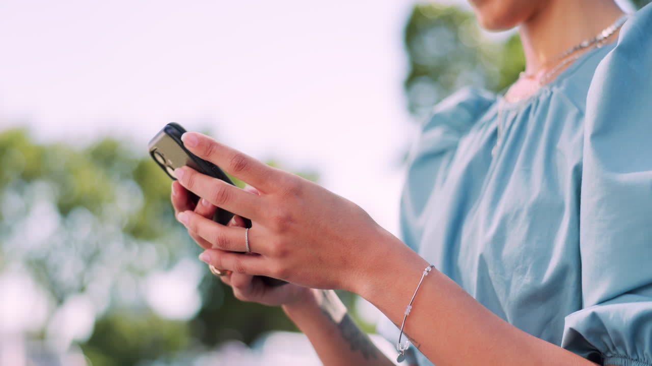 손, 전화 및 타이핑을 위해 공원에 있는 여성