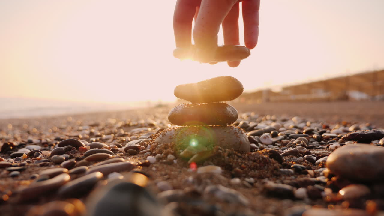 손은 피라미드에 돌을 넣는다 태양 광선은 그의 손가락을 통해 빛난다