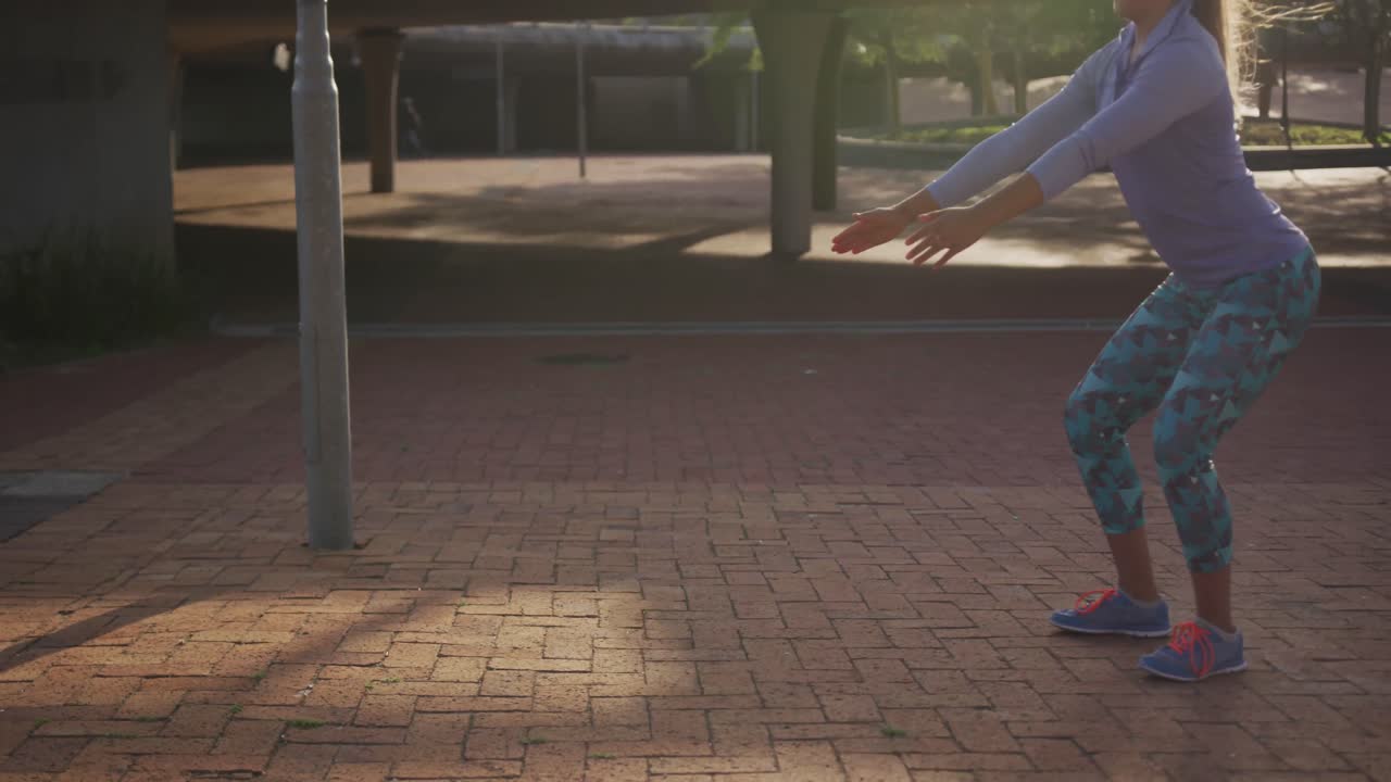 Donna caucasica che fa squat in un parco