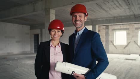 retrato de un arquitecto y una arquitecta caucásicos en un sitio de construcción.